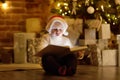 Little boy reading a magic book in decorated cozy living room Royalty Free Stock Photo