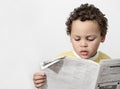 Little boy reading newspaper stock photo