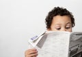 Little boy reading newspaper stock photo