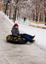 A little boy on a sled and goes down an ice slide Royalty Free Stock Photo