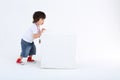 Little boy in red sneakers pushes large white cube Royalty Free Stock Photo