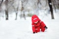 Little boy in red winter clothes having fun with snow during snowfall Royalty Free Stock Photo