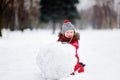 Little boy in red winter clothes having fun with snowman Royalty Free Stock Photo