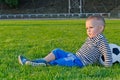 Little boy relaxing with his soccer