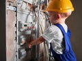 Little boy repairing electrical control panel at home. Royalty Free Stock Photo