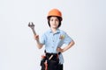 A little boy in repairman form and helmet. Boy holds a adjustable spanner in his hand.