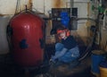 Little boy repairs water boilers in basement