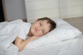 Little boy resting in white bed with eyes open Royalty Free Stock Photo