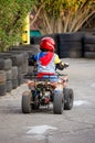 Little Boy Rides a Motorcycle ATV with Four Wheels. Outdoor Activity for Children on an Electric Racing Quad Bike Machine