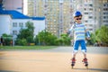 Little boy riding on rollers in the summer in the Park. Happy child in helmet learning to skate Royalty Free Stock Photo