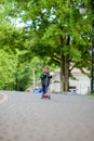 Little boy riding scooter in city park in aummer. Kids sports outdoors. Happy child playing with his scooter. Kid learn to ride Royalty Free Stock Photo