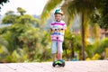 Little boy riding scooter. Kids ride kick board Royalty Free Stock Photo