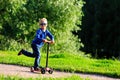 Little Boy Riding Scooter In Summer