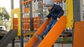 Little boy riding on the slide on children playground. Concept of child development, sports and education. Royalty Free Stock Photo