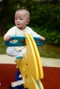 Little boy riding an yellow horse at the playground Royalty Free Stock Photo