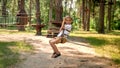 Little boy riding on the zip-line at forest between trees. Active childhood, healthy lifestyle, kids playing outdoors, children in Royalty Free Stock Photo