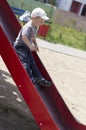 Little boy rids on the slide