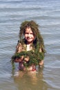 Little boy with river grass on head