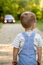 A little boy on a road in the forest. Danger on the road. The child is in danger on the road