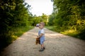 A little boy on a road in the forest. Danger on the road. The child is in danger on the road