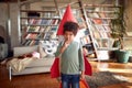 A little boy with a rocket toy on his back digs his nose while playing at home. Home, game, childhood Royalty Free Stock Photo