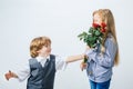 Little Boy with a rose for his teen girlfriend, romantic children, isolated on white background. Little boy giving Royalty Free Stock Photo