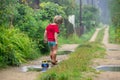 Little boy in rubber boots pulls a toy toy car tractor on a rope Royalty Free Stock Photo