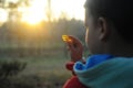 A little boy in rubber boots walks through the forest and explores stones, a mineral. Child looking at rocks. Royalty Free Stock Photo