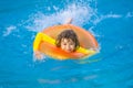 Little boy with rubber ring in swimming pool. Summertime fun. Little kid swimming in pool. Kid in swimming pool. Kid Royalty Free Stock Photo