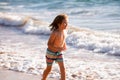 Little boy running on beach shore splashing water in blue sea. Kid walking the summer beach. Royalty Free Stock Photo