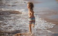 Little boy running on beach shore splashing water in blue sea. Kid walking the summer beach. Royalty Free Stock Photo