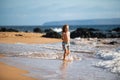 Little boy running on beach shore splashing water in blue sea. Kid walking the summer beach. Royalty Free Stock Photo