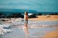 Little boy running on beach shore splashing water in blue sea. Kid walking the summer beach. Royalty Free Stock Photo