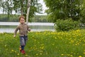 Little boy running in the field of dandelions Royalty Free Stock Photo