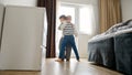 Little boy running on the floor of his home and being embraced by his loving mother. Parental love and the joys of Royalty Free Stock Photo