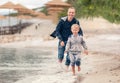 Little boy running with his father at the surf line Royalty Free Stock Photo