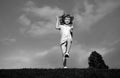 Little boy running and jumping on the grass near a spring green meadow on blue sky. Happy child girl playing on sunny Royalty Free Stock Photo