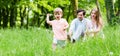 Little boy running over meadow with family in back Royalty Free Stock Photo