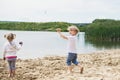 Little boy running on a sand near a pond Royalty Free Stock Photo