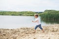 Little boy running on a sand near a pond Royalty Free Stock Photo