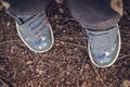Little boy`s dirty sneakers on the ground outdoors, top view. Royalty Free Stock Photo