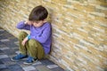 Little boy sad sitting alone at school hides his face. Isolation and bullying concept. Kid sad and unhappy, child was crying, Royalty Free Stock Photo