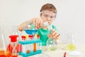 Little boy in safety goggles studies chemical practice in laboratory Royalty Free Stock Photo