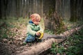 Little boy sawing a fallen tree in the forest Royalty Free Stock Photo