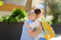 Little boy says goodbye and hugging to his father before going to school. Dad brought his son by car. Quality education for Royalty Free Stock Photo