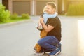 Little boy says goodbye and hugging to his father before going to school. Education for children. First day of school. Child`s