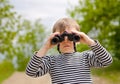 Little boy scanning the woods with binoculars Royalty Free Stock Photo