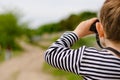 Little boy scanning the woods with binoculars