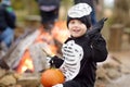 Little boy in scary skeleton costume at halloween celebrations party in forest