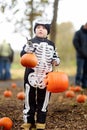 Little boy in scary skeleton costume at halloween celebrations party in forest